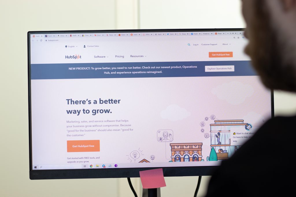 HubSpot website page on screen, man using service, Illustrative Editorial