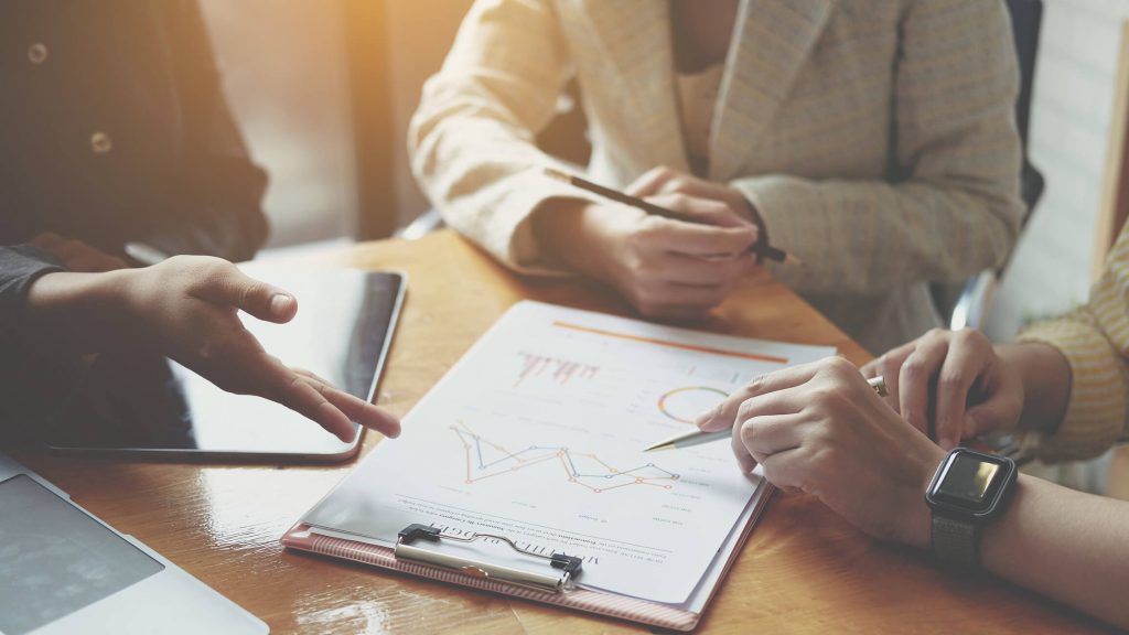 Businesswoman holding pens and holding graph paper are meeting to plan sales to meet targets set in next year