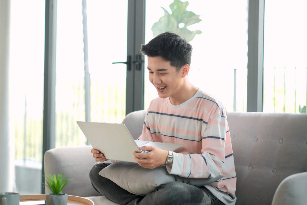 excited young male relax on couch triumph read good news in email