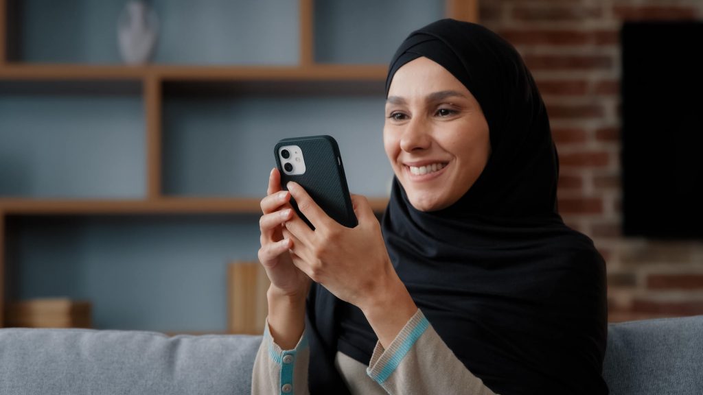 woman using smartphone at home with smile browsing surfing social media