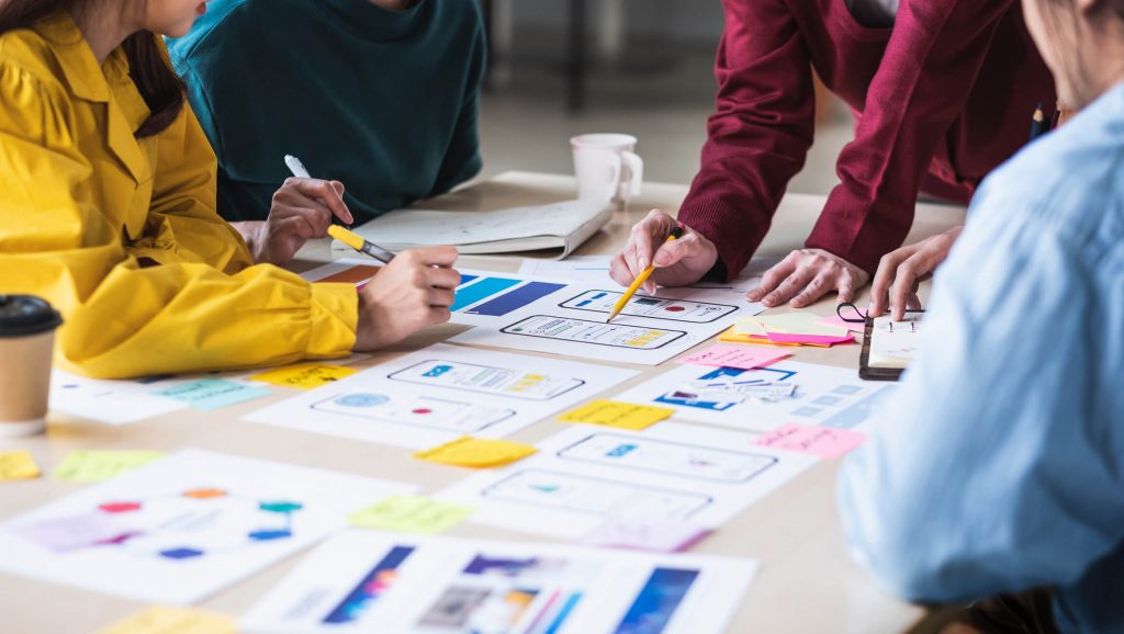 Close up ux developer and ui designer brainstorming about mobile app