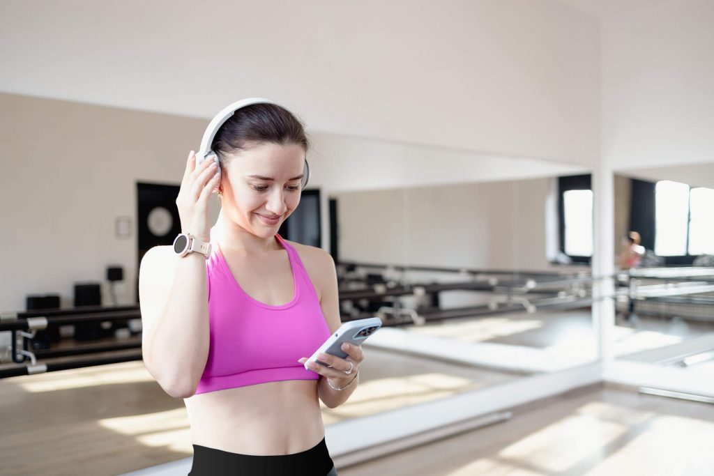 Young woman listening to music with earphones on smart phone app