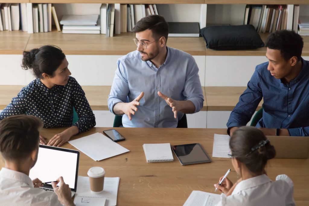 male manager talking to diverse business people at meeting
