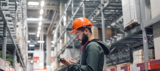 builder with tablet at warehouse checking stock availability via a tablet