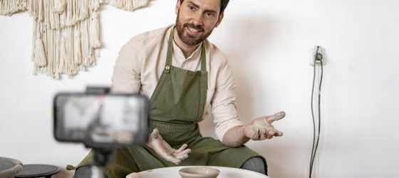 Male potter creating ceramics while recording video blog