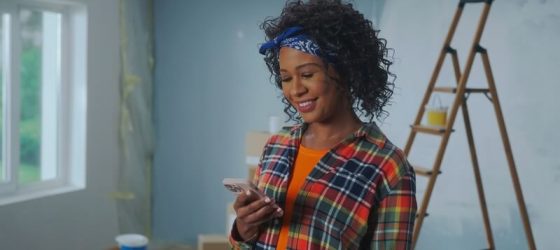 a woman looking at phone screen and smiling